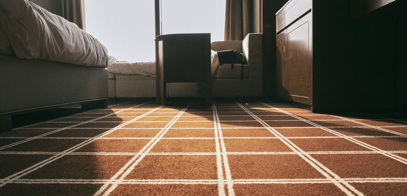 Hotel room flooring with commercial-grade carpet designed for comfort and durability