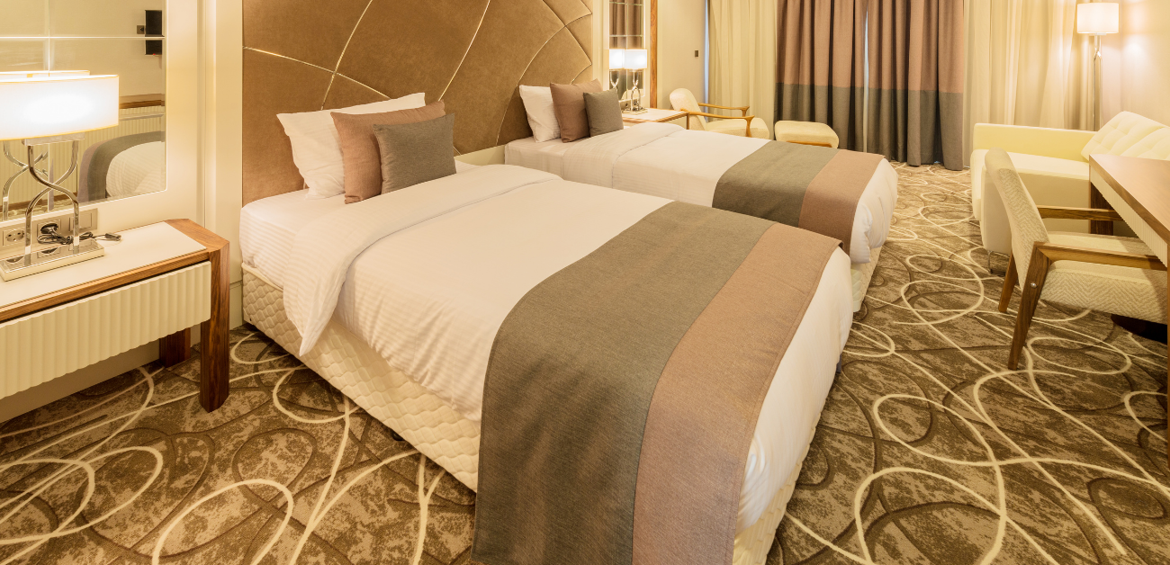 Hotel bedroom with patterned carpet designed for long-term guest use
